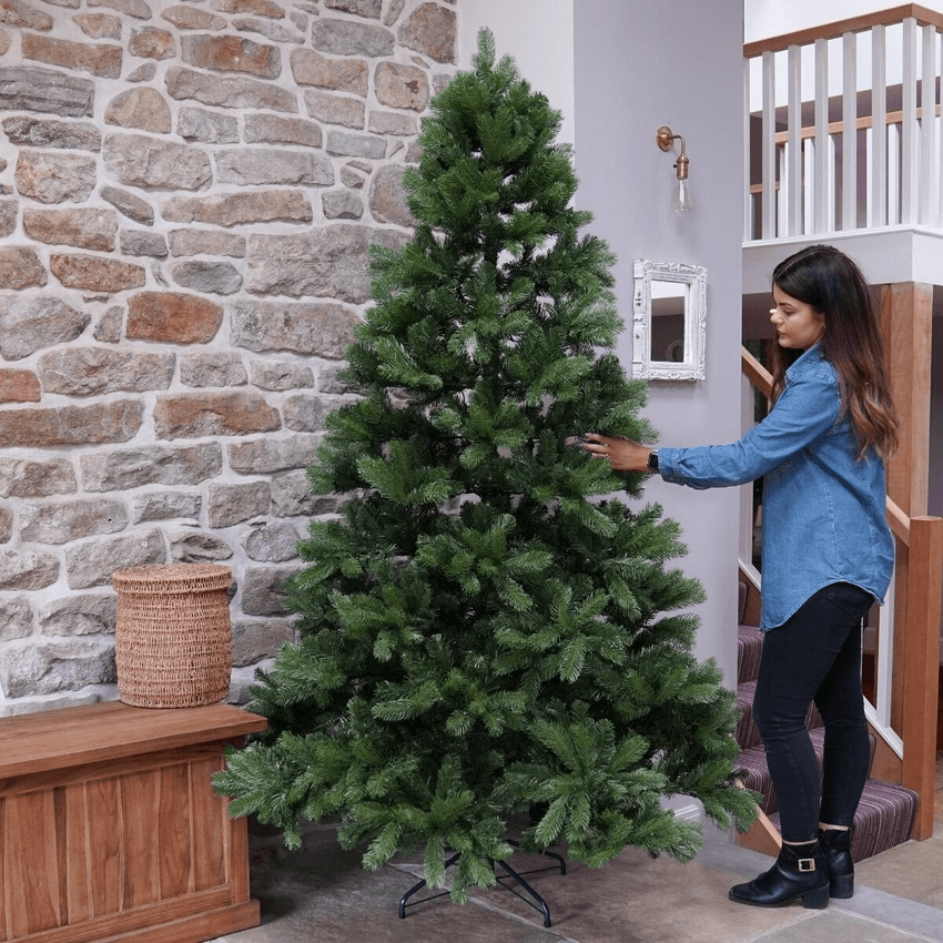 Mayberry-Spruce-7-Ft-Christmas-Tree-women-decorating-christmas-tree.png